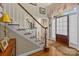 Elegant staircase with wooden handrail and white trim near the front door at 204 Limerick Dr, Matthews, NC 28104