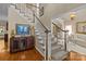 Elegant staircase with carpet runner, wooden handrail, white trim, and decorative console table at 204 Limerick Dr, Matthews, NC 28104