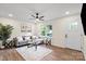 Bright living room with hardwood floors, fan, neutral paint, gray sofa, front door, and large front window at 232 Avery St, Fort Mill, SC 29715