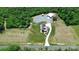 Beautiful aerial view features a home with two outbuildings with metal roofs, surrounded by green and wooded areas at 25674 Old School Rd, Oakboro, NC 28129