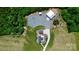 Expansive aerial view features a home, two outbuildings, and driveway, surrounded by fields and forest at 25674 Old School Rd, Oakboro, NC 28129