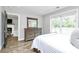 Light bedroom featuring wood-look floors, dresser, and a view of the living room at 25674 Old School Rd, Oakboro, NC 28129