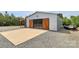 Modern shed with wood paneled sliding doors, gravel driveway, and concrete pad at 25674 Old School Rd, Oakboro, NC 28129