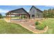 Exterior view featuring modern architecture, a carport, an outdoor dining area, and lush landscaping at 25674 Old School Rd, Oakboro, NC 28129
