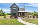 Charming exterior view of a modern farmhouse with a stone pathway, lovely landscaping, and a welcoming front porch at 25674 Old School Rd, Oakboro, NC 28129
