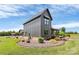 Beautiful exterior showcasing a modern home with gray siding, a manicured lawn, and tasteful landscaping at 25674 Old School Rd, Oakboro, NC 28129