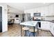 Bright kitchen with white cabinets, stainless steel appliances, island seating, and wood floors at 25674 Old School Rd, Oakboro, NC 28129