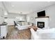 Bright living room with a cozy fireplace, comfortable seating, and hardwood floors at 25674 Old School Rd, Oakboro, NC 28129