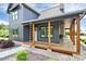 Inviting front porch with wooden columns, stone accents, and a view of the meticulously landscaped front yard at 25674 Old School Rd, Oakboro, NC 28129
