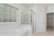 Bright bathroom featuring a glass-enclosed shower, large tub, and natural light from the window at 3007 Sandbox Cir, Indian Trail, NC 28079