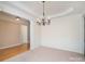 Dining room featuring elegant chandelier and wainscoting, open to hallway with hardwood floors at 3007 Sandbox Cir, Indian Trail, NC 28079