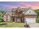Beautiful brick home showcasing manicured lawn and landscaped garden beds with a two-car garage at 3007 Sandbox Cir, Indian Trail, NC 28079