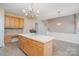 Open kitchen with center island, chandelier, and easy access to the living room at 3007 Sandbox Cir, Indian Trail, NC 28079