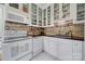 Charming kitchen with white cabinets, brick backsplash, black counters, and classic appliances at 301 W 10Th St # 402, Charlotte, NC 28202