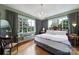 Relaxing main bedroom with a large bed, hardwood floors, large windows, and chandelier at 301 W 10Th St # 402, Charlotte, NC 28202