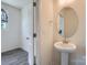 Clean half-bathroom with pedestal sink, modern fixtures, wood-look flooring, and natural lighting at 3015 Howell Mill Rd, Charlotte, NC 28208