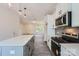 Modern kitchen with island, stainless appliances, gray backsplash, open layout, and updated lighting at 3015 Howell Mill Rd, Charlotte, NC 28208