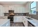 Stylish kitchen with white cabinets, gray backsplash, stainless steel appliances, and quartz countertops at 3015 Howell Mill Rd, Charlotte, NC 28208