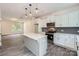 Bright kitchen features an island with quartz countertops, gray backsplash, stainless steel appliances, and modern globe lighting at 3015 Howell Mill Rd, Charlotte, NC 28208