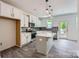 Well-lit kitchen features an island with quartz countertops, stainless steel appliances, and gray backsplash at 3015 Howell Mill Rd, Charlotte, NC 28208