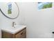Modern bathroom featuring stylish vanity with a vessel sink, round mirror, and a window offering natural light at 302 Wesley Heights Way, Charlotte, NC 28208