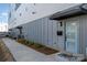 Modern townhome showing the blue front door with a black awning and gray wood siding at 302 Wesley Heights Way, Charlotte, NC 28208