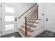 Modern staircase featuring wooden steps, black metal railings, and a white door at 302 Wesley Heights Way, Charlotte, NC 28208