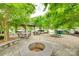 Relaxing common area with seating, picnic tables, and fire pit is surrounded by lush greenery at 306 Willow Wood Ct, Matthews, NC 28104