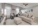 Sun-filled living room shows a ceiling fan, neutral walls, and a view into the dining room at 306 Willow Wood Ct, Matthews, NC 28104