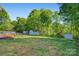 Expansive backyard featuring lush greenery, mature trees, storage sheds, and a wooden deck, perfect for outdoor enjoyment at 308 Southland Rd, Huntersville, NC 28078