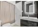 Modern bathroom with gray vanity, and tiled tub and shower at 308 Southland Rd, Huntersville, NC 28078