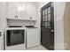 Well-lit laundry room with washer, dryer, cabinetry, and access to the home's exterior at 308 Southland Rd, Huntersville, NC 28078