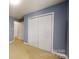 A bedroom with blue walls, cream-colored carpet, and a double closet with sliding doors at 3124 Banks St, Lincolnton, NC 28092