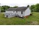 Back of house with deck, showing neutral siding, dark roof, and well-maintained lawn at 3124 Banks St, Lincolnton, NC 28092
