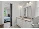 Bathroom featuring double sinks with marble countertops, white cabinets and drawers with a large mirror at 327 Kenway Loop, Mooresville, NC 28117