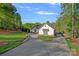 A beautiful well maintained yard and driveway approaching a stylish farmhouse exterior at 327 Kenway Loop, Mooresville, NC 28117