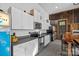 Garage kitchen with white cabinets, stainless appliances, barstool seating and vintage details at 327 Kenway Loop, Mooresville, NC 28117