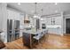 Modern kitchen featuring stainless steel appliances, white cabinets, and a granite-topped island with seating at 327 Kenway Loop, Mooresville, NC 28117