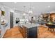 Open concept kitchen with stainless appliances, farm sink, and a view into the inviting living room at 327 Kenway Loop, Mooresville, NC 28117
