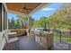 Outdoor kitchen with stone facade, grill, and comfortable seating area overlooking lush greenery at 327 Kenway Loop, Mooresville, NC 28117