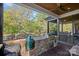 Covered outdoor kitchen with built-in grill, stone accents, and a view of the serene lake at 327 Kenway Loop, Mooresville, NC 28117