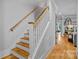 Traditional staircase with wood treads and white risers, leading to a living area with hardwood floors at 327 Kenway Loop, Mooresville, NC 28117