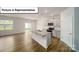 Open-concept kitchen and living area featuring an island, modern appliances, and sliding glass door at 3404 Lacebark Ln, Gastonia, NC 28056