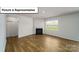 Bright living room boasts beautiful hardwood floors, fireplace and large windows at 3404 Lacebark Ln, Gastonia, NC 28056