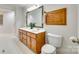 Bathroom featuring wooden cabinets, double sinks, a large mirror and a toilet at 4307 Edgeland Rd, Edgemoor, SC 29712