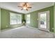 An airy bedroom features carpet, multiple windows for natural light, and a door to the outside at 4307 Edgeland Rd, Edgemoor, SC 29712