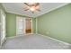 Bright room with large windows and neutral carpet, featuring a ceiling fan and exterior door at 4307 Edgeland Rd, Edgemoor, SC 29712