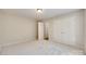 A clean bedroom with neutral walls and carpet, featuring a closet and access to another room at 4307 Edgeland Rd, Edgemoor, SC 29712