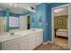 Stylish bathroom featuring a double sink vanity, tiled flooring, and blue accent walls, plus bedroom view at 461 Pier Point Nw Ct, Concord, NC 28027