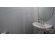 A tidy half-bathroom featuring a pedestal sink, oval mirror, and light gray paint at 461 Pier Point Nw Ct, Concord, NC 28027